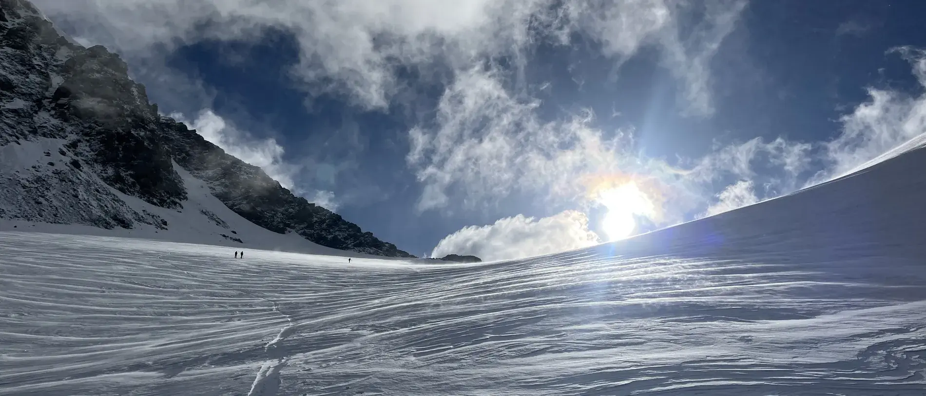 Gletscher im Gegenlicht mit Aufstiegsspur zur Morgensonne